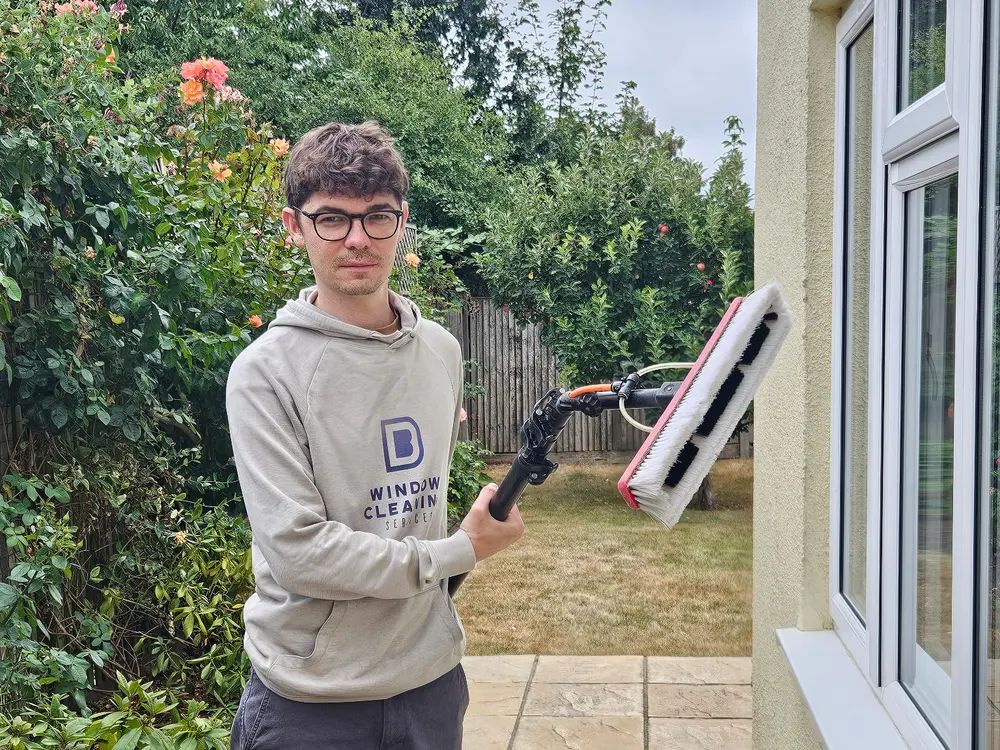 Ben Drummond of B D Window Cleaning Services holding a pure-water brush